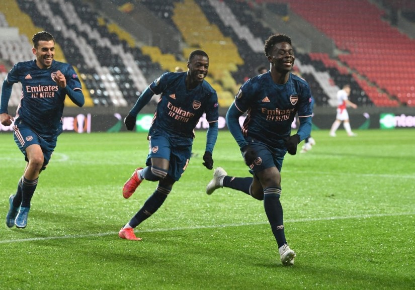 PRAGUE, CZECH REPUBLIC - APRIL 15: (R) Bukayo Saka celebrates scoring the 3rd Arsenal goal with (L) Dani Ceballos and (2ndR) Nicolas Pepe during the UEFA Europa League Quarter Final Second Leg match between Slavia Praha and Arsenal FC at Eden Arena on April 15, 2021 in Prague, Czech Republic. Sporting stadiums around Europe remain under strict restrictions due to the Coronavirus Pandemic as Government social distancing laws prohibit fans inside venues resulting in games being played behind closed doors. (Photo by Stuart MacFarlane/Arsenal FC via Getty Images)