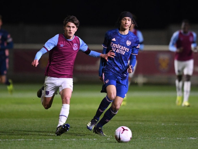 ROMFORD, ENGLAND - APRIL 16: Kido Taylor -Hart of Arsenal passes the ball under pressure from Freddie Potts of West Ham during the FA Youth Cup match between West Ham United U18 and Arsenal U18 at Rush Green on April 16, 2021 in Romford, England. (Photo by David Price/Arsenal FC via Getty Images)