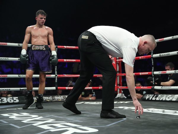 BEN SHALOM’S BOXXER FIGHT NIGHT17/12/22 BOURNEMOUTH INTERNATIONAL CENTRE PIC LAWRENCE LUSTIG/BOXXER LIGHTWEIGHT CONTEST CORI GIBBS v JIMMY FIRST REF DEDUCTS ANOTHER POINT FROM GIBBS FOR PERSISTANT LOSS OF HIS MOUTH SHIELD